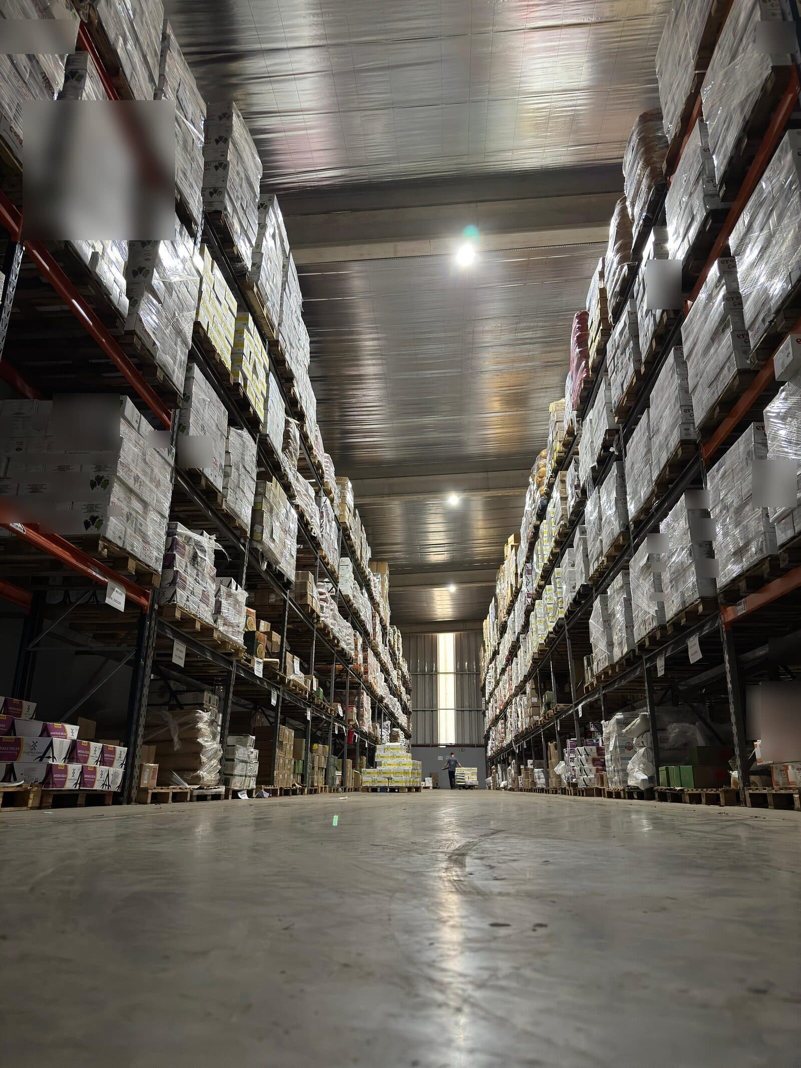 Corredor central do centro de distribuição, com racks paletizados dos dois lados